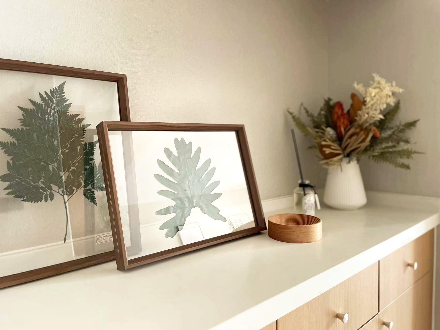 植物画と花器、ドライフラワーを並べたディスプレイ