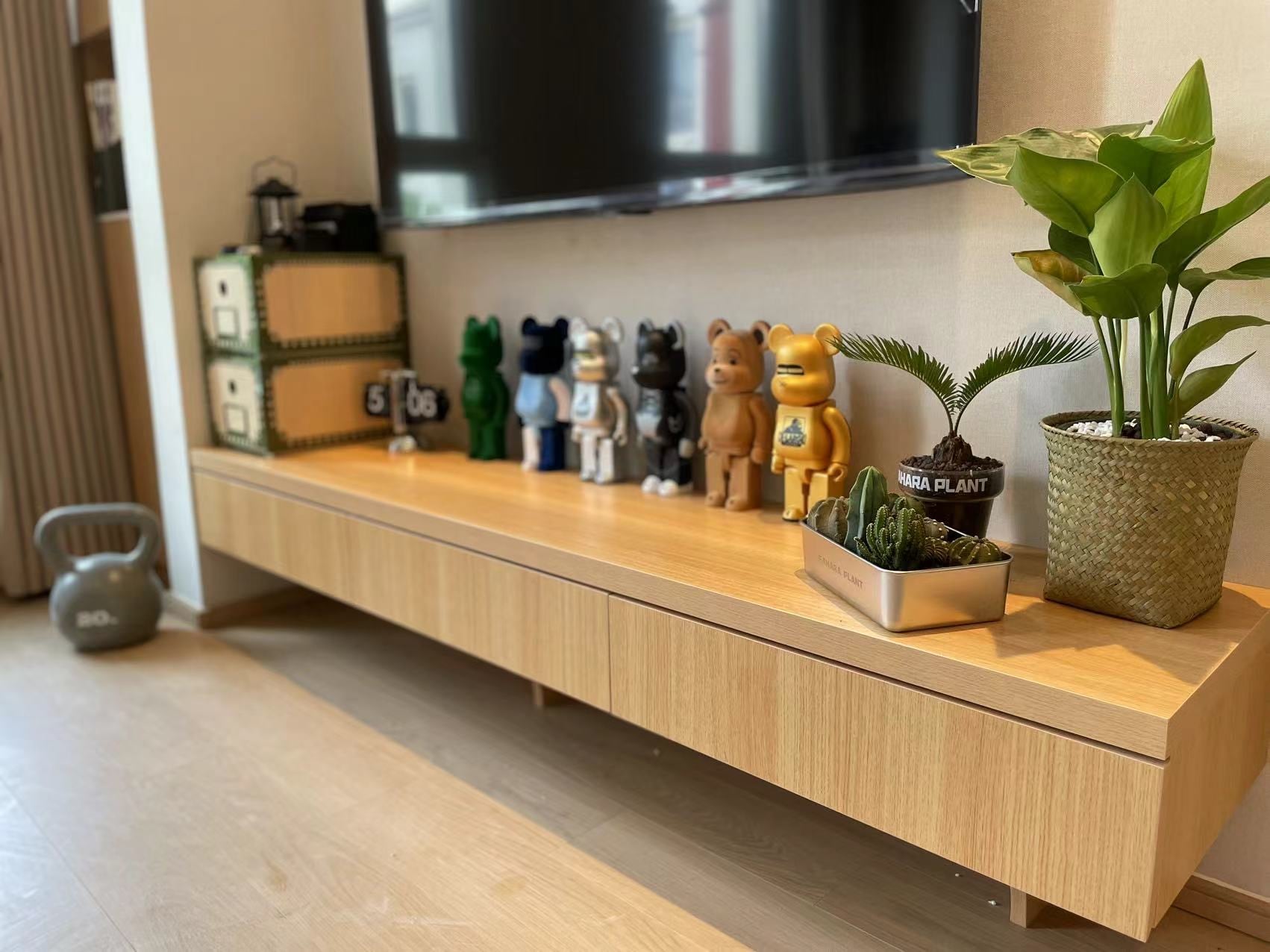 木のテレビボードに並べたオブジェと観葉植物